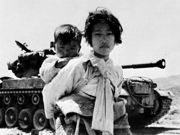 Ragazzina coreana con il fratello sulle spalle a nord di Seul durante la guerra di Corea, 1951 © courtesy UN Photo/United States Navy